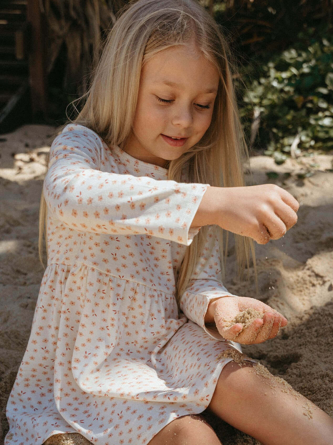 Young girl playing with sand on a beach